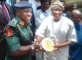 National Youth Service Corps (NYSC) Director-General, Brigadier-General Sule Kazaure (left), presenting a souvenir to the Resident Electoral Commissioner of INEC in Edo, Mr Sam Olumekun, during his visit to INEC office, in Edo. PHOTO: NAN