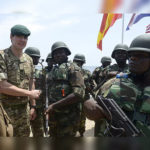 A British soldier shakes hand with his Nigerian counterpart during a joint military exercise between Nigerian