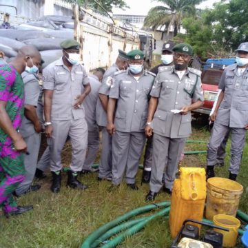 Oyo/Osun Area Controller of Customs, Abdulkadir Adamu (second right) with other officers showing journalists the hoses and jerrycans intercepted by his officers