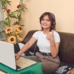 A call center agent dressed in smart casual happily working in a