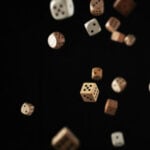 Dice falling and scattering in mid-air, symbolizing chance and excitement.