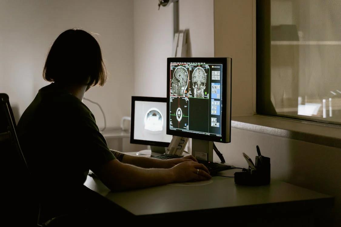 A lady in front of a screen with medical imaging
