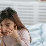 a girl applying something on her face