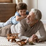 Elderly man and boy playing on the floor