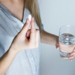 A woman taking a drug. What are the signs you need to deworm ASAP