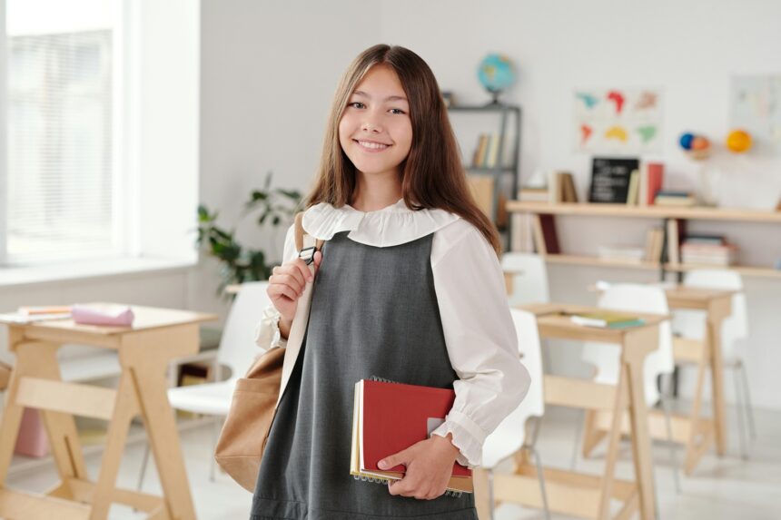 teenager holding books in a school