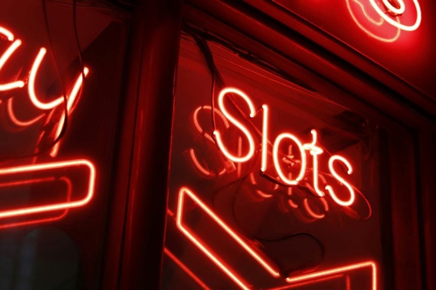 red and white neon light signange with the words slots