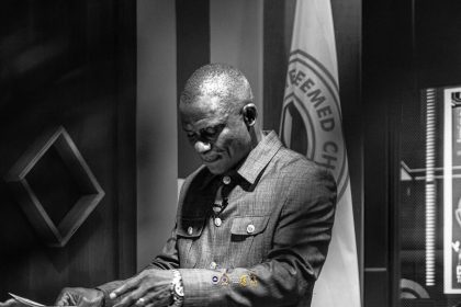 Pastor Sola Owoeye praying,