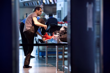 man removing his shoe at US airport,