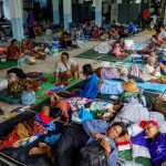 People rest at a shelter, following recent clashes along the disputed border between Thailand and Cambodia