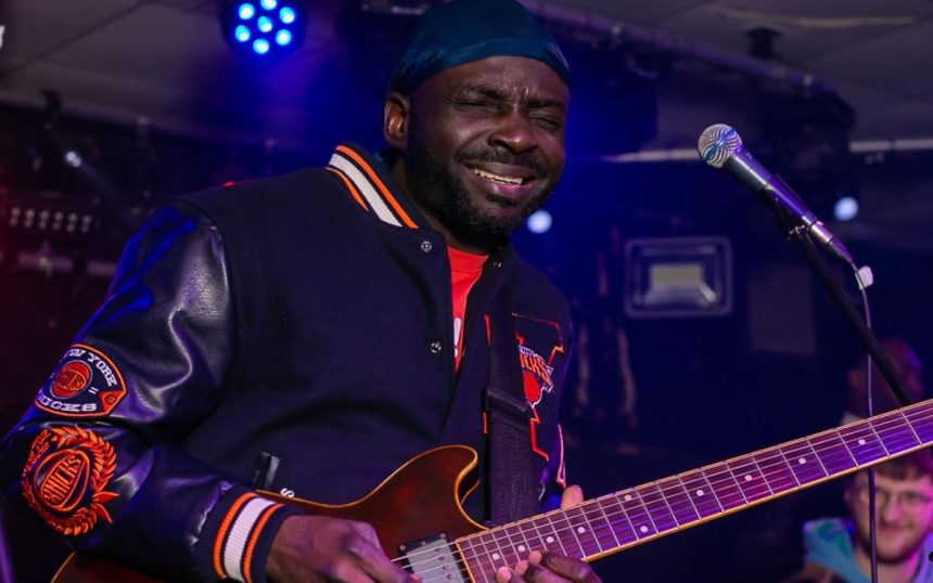 James Toba Ojo playing guitar
