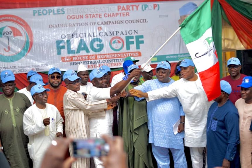The National Vice Chairman of the Peoples Democratic Party, South West, Hon. Kamorudeen Ajisafe, handing over the party's flag to the candidate for the August 16 bye-election of the Remo Federal Constituency, Bolarinwa Oluwole, held at the Akarigbo's Hall, Sagamu, on Monday.