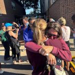 Mourners at the scene of the incident after gunman opened fire through the windows of a church at the Annunciation Catholic School in Minneapolis