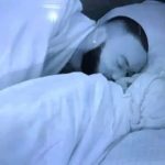 Dede and Kola on facing each other on the bed