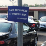 car parked at owners' risk sign