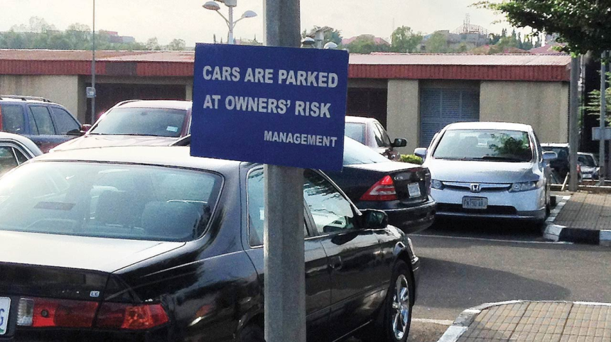car parked at owners' risk sign