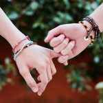 two persons holding hands