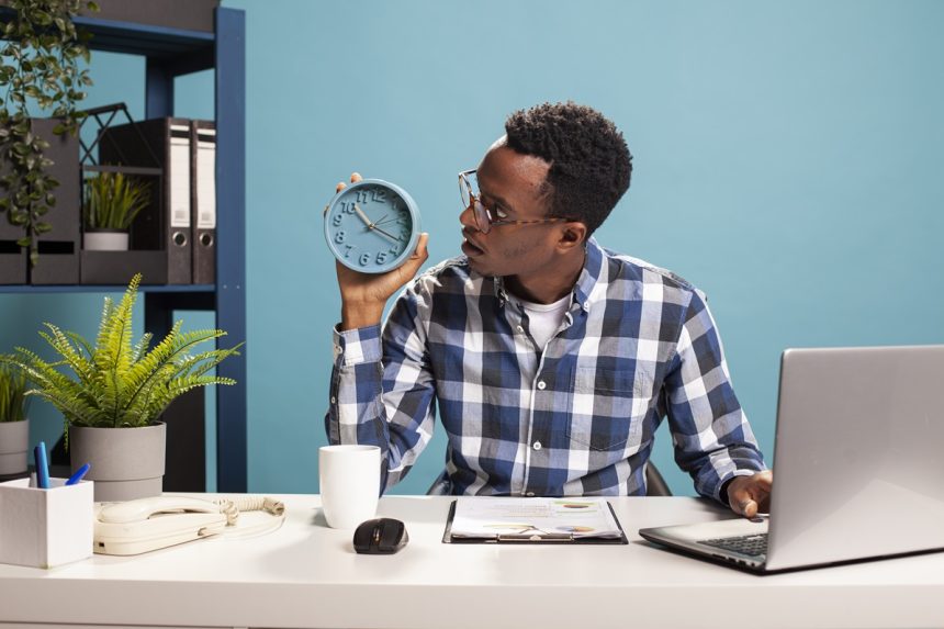 Surprised manager looking at clock