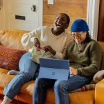 two women laughing on the couch