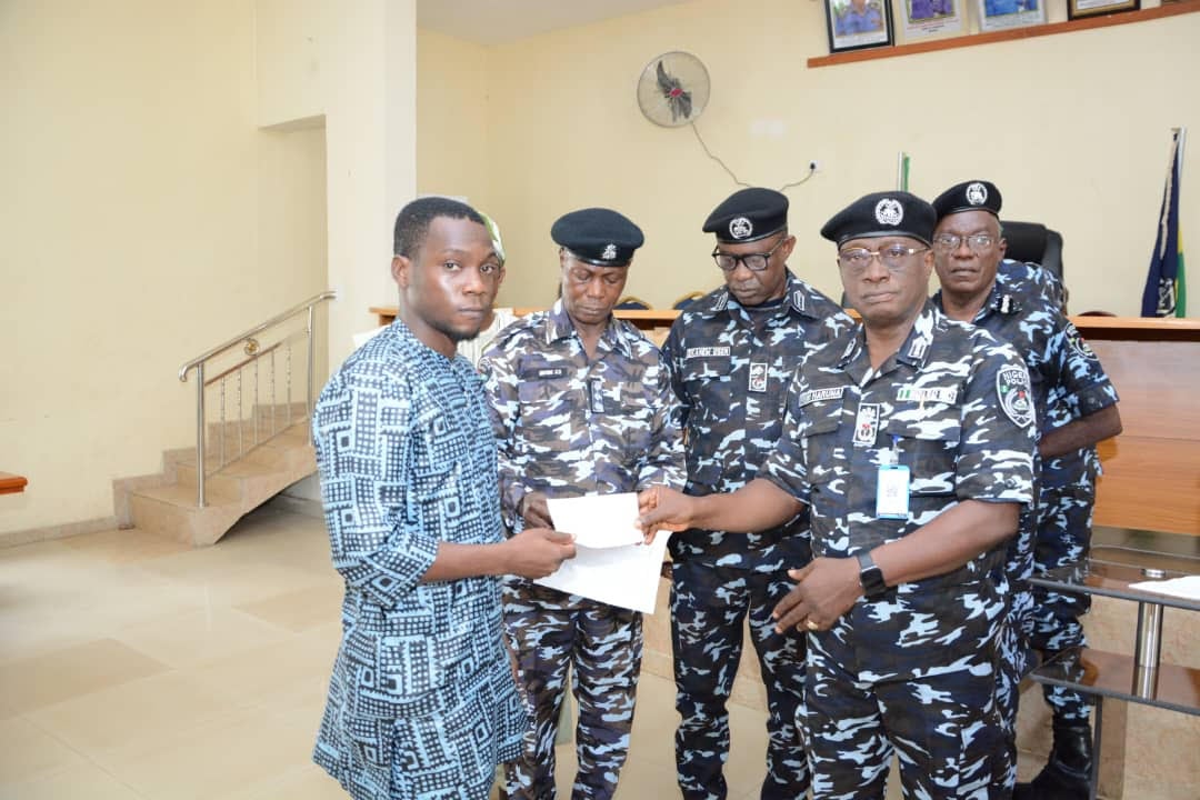 Commissioner of Police, Oyo State Command, Femi Haruna (first right) presenting cheque to one of the beneficiaries of Group Life Assurance and IGP's welfare scheme