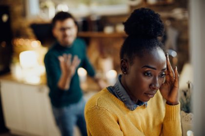 Young black woman feeling worried while having relationship problems with her boyfriend at home.