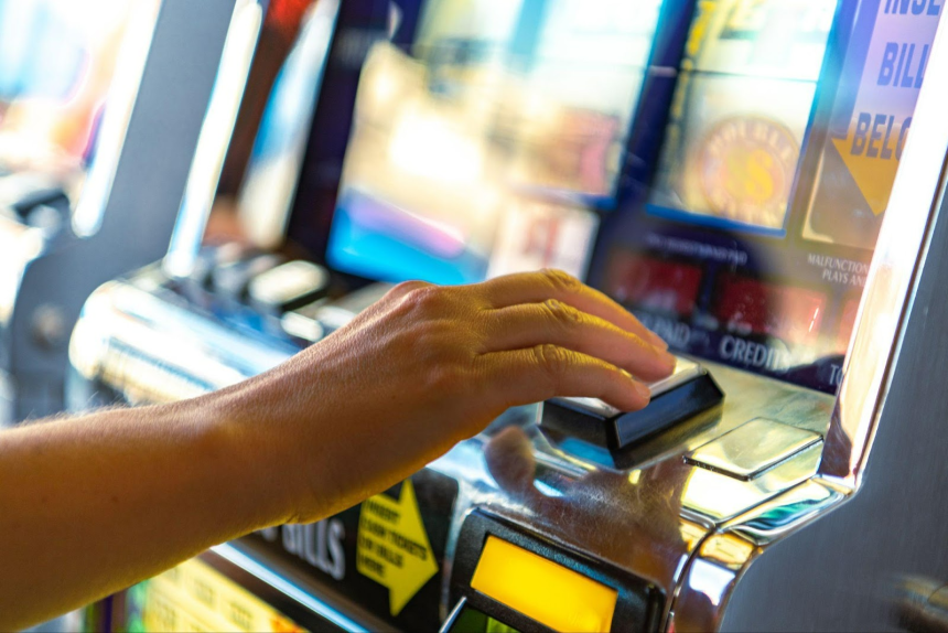 hands playing at the slot machine
