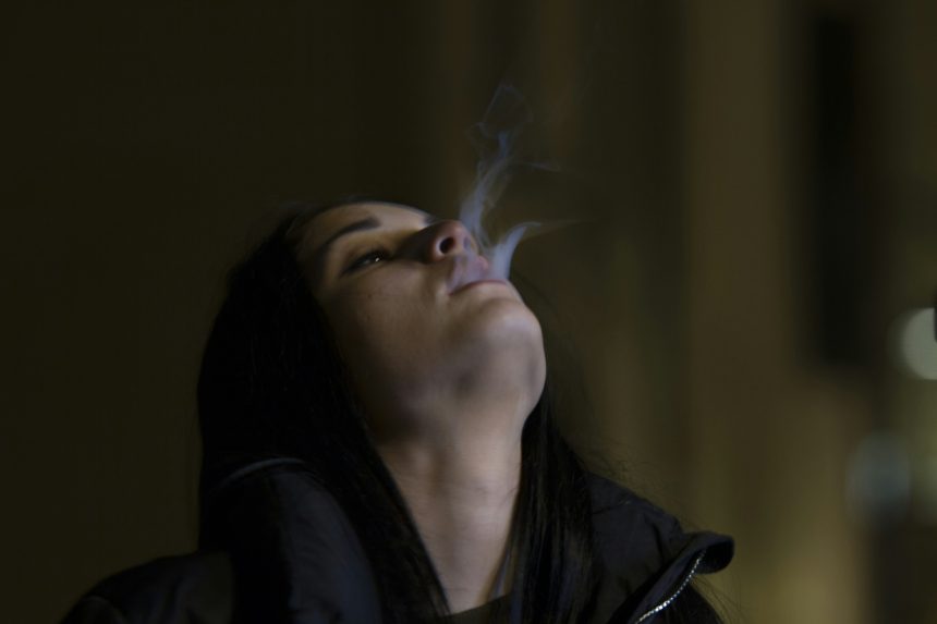 woman puffing cigarette smoke