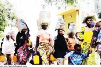 Internally displaced families walk through a community in northern Nigeria after fleeing bandit violence.
