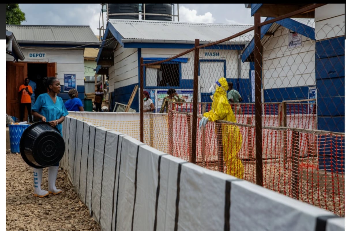 A healthcare worker speaks to a colleague at the Ebola treatment center in Beni, North Kivu province, Congo,