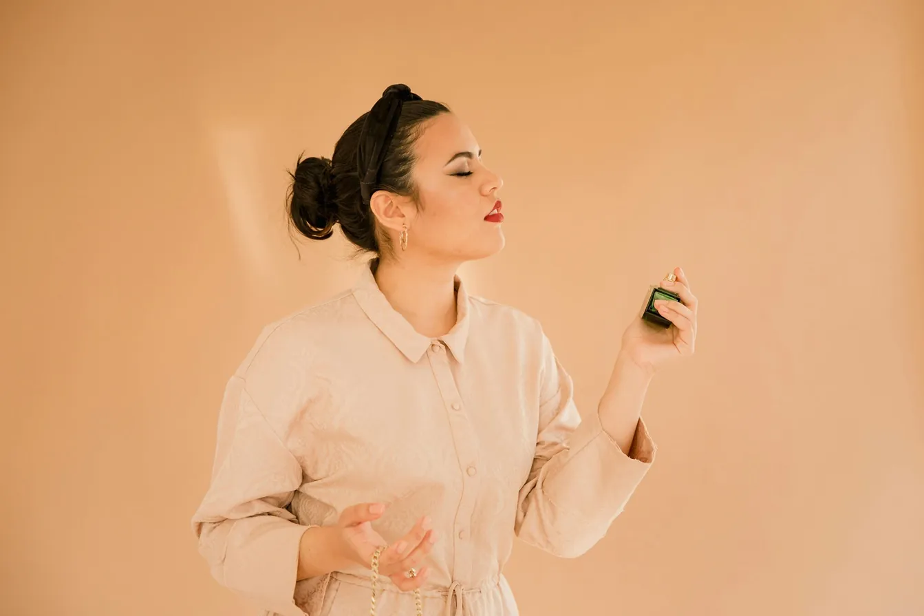 a woman spraying perfume on herself