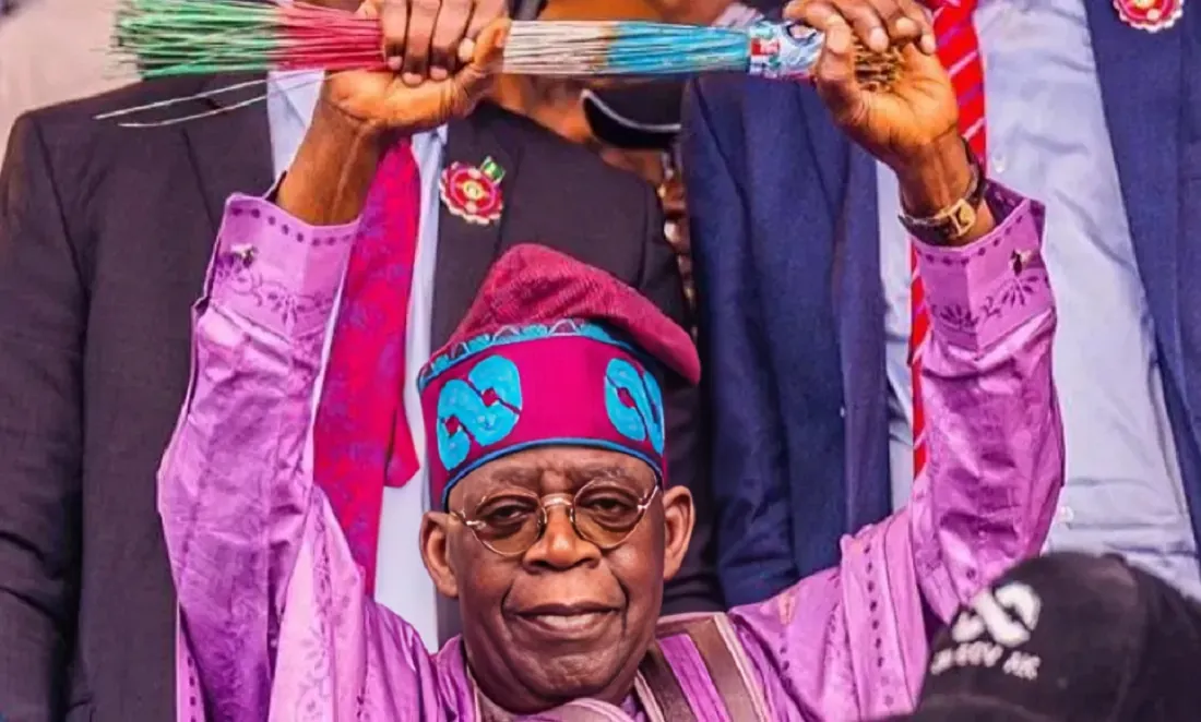 President Bola Tinubu raising APC broom